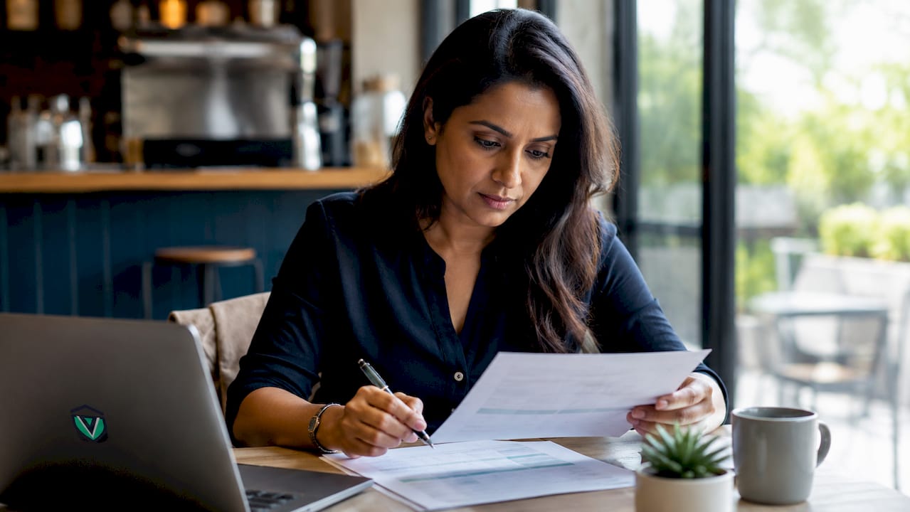 Person reviewing permit checklist document at desk