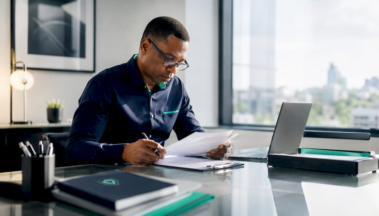 Man reviewing tax and license documents at desk