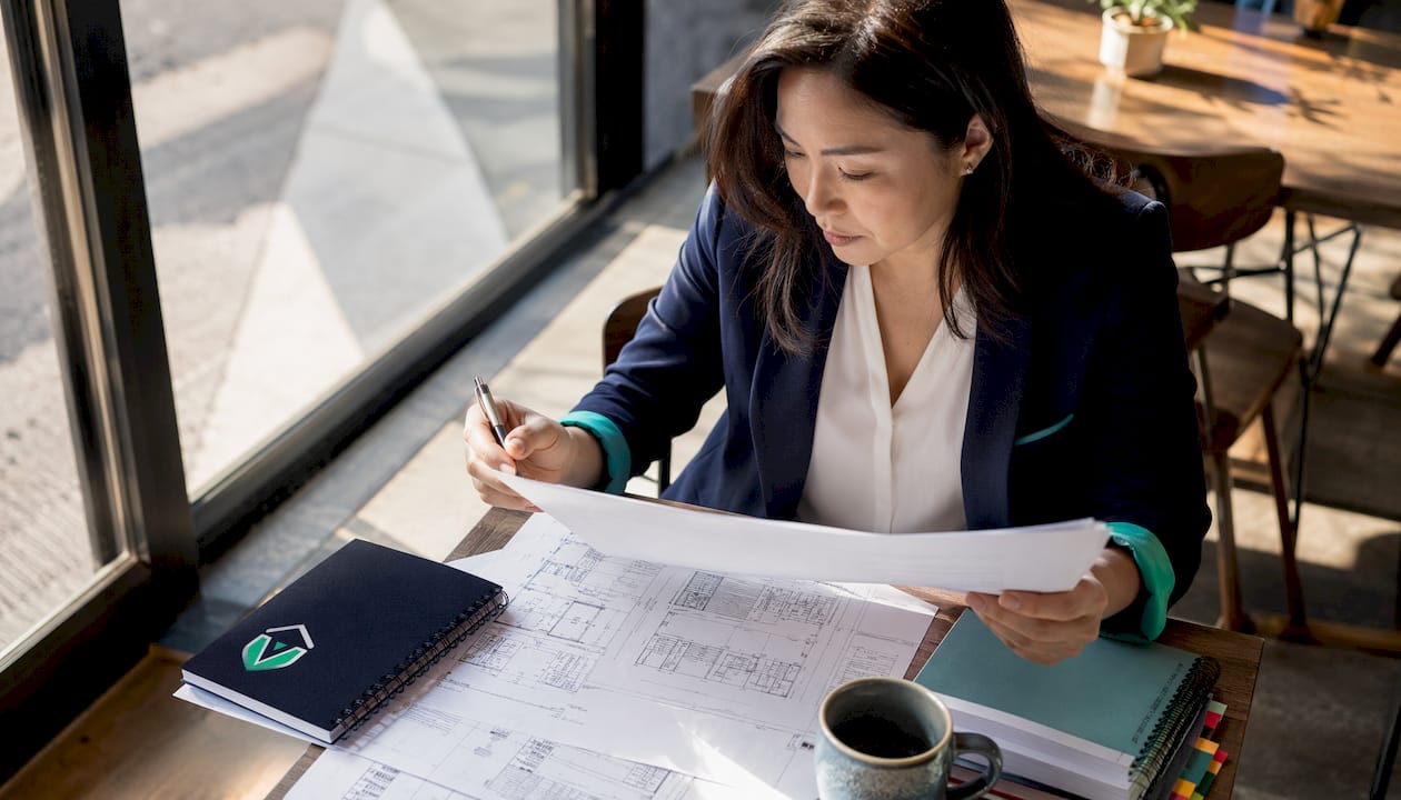 Woman reviewing franchise permit documents at desk