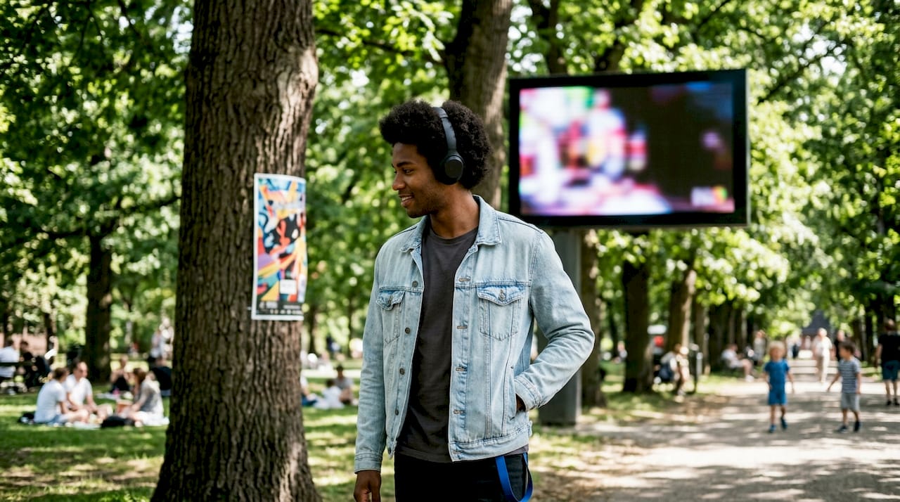 Man walking past outdoor and digital ads