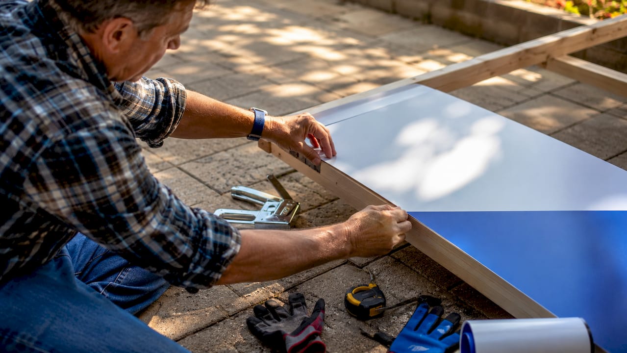 Hands assembling commercial yard sign on table