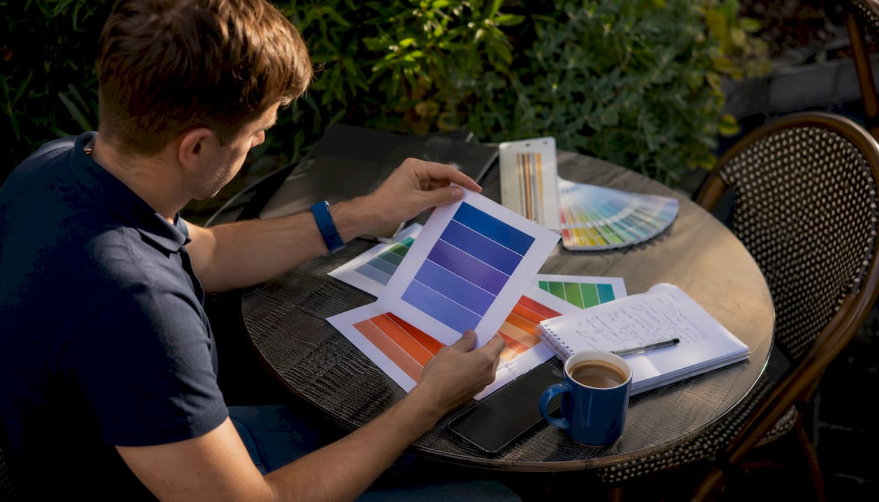 Marketer examining printed sign samples at desk