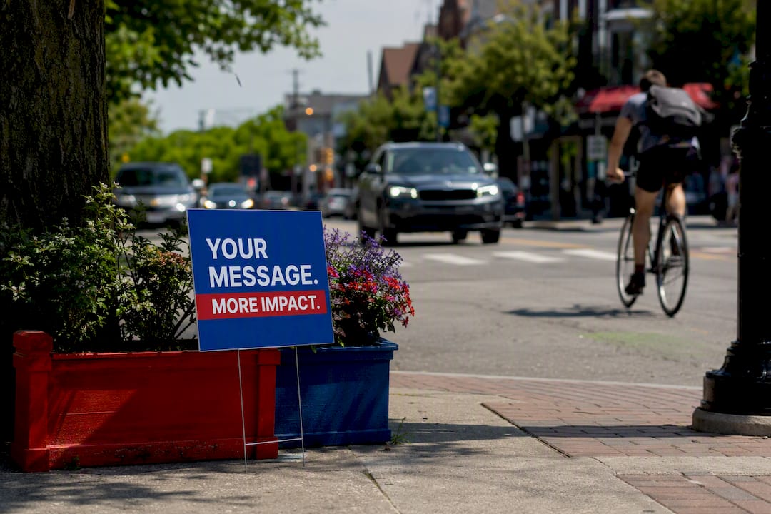Yard signs placed at busy street corner