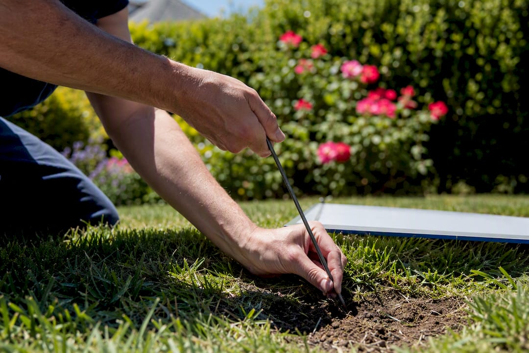 Hands angling yard sign stake in windy yard