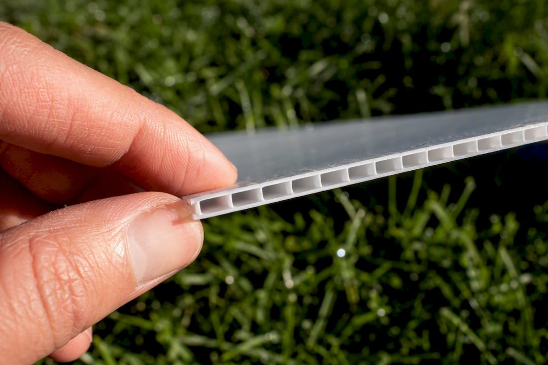 Hand feeling edge of corrugated plastic yard sign
