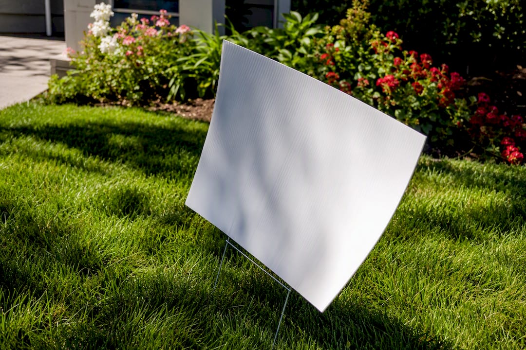 Yard sign bending under strong wind gust