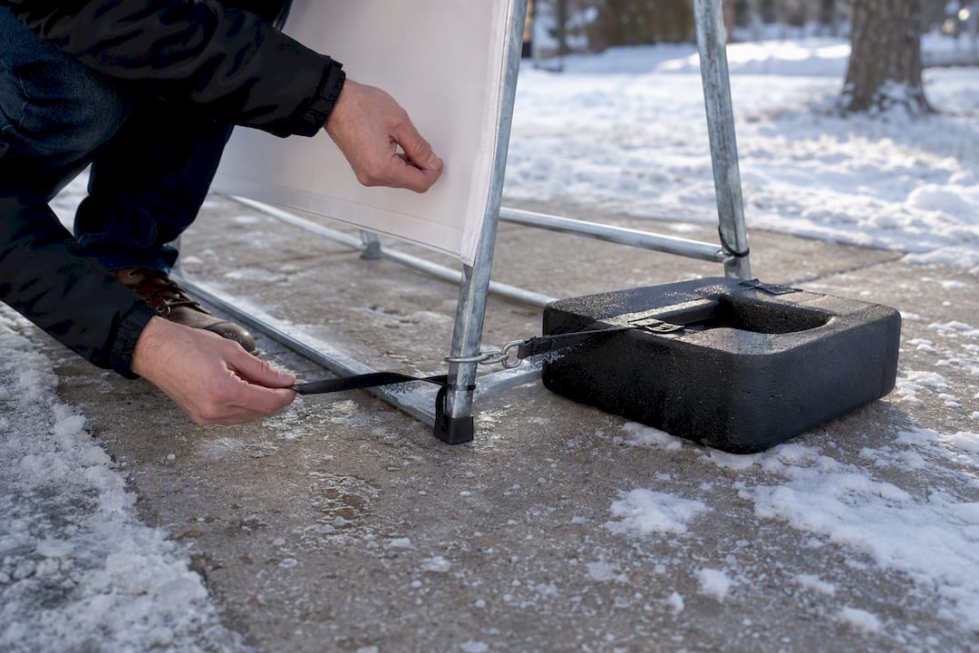 Weighted frame securing sign on snowy pavement