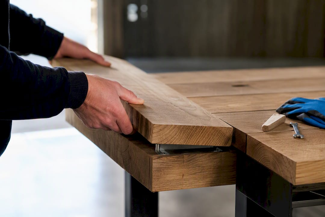 En hand som byter ut en bräda i ett modulärt bänkbord
