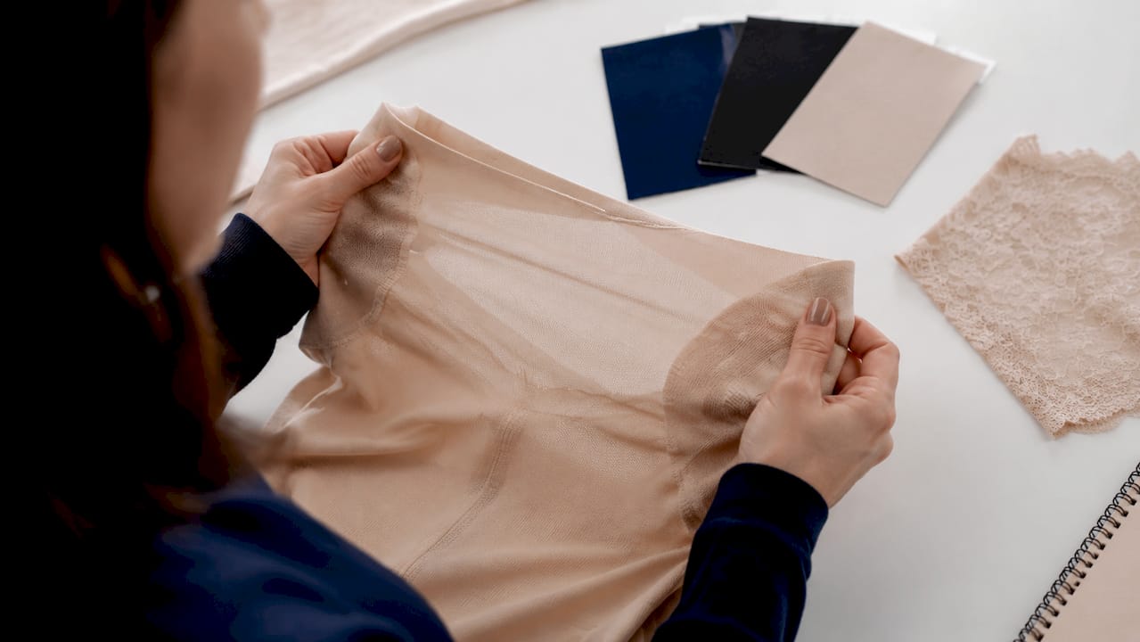 Hands stretching nylon-spandex fabric sample