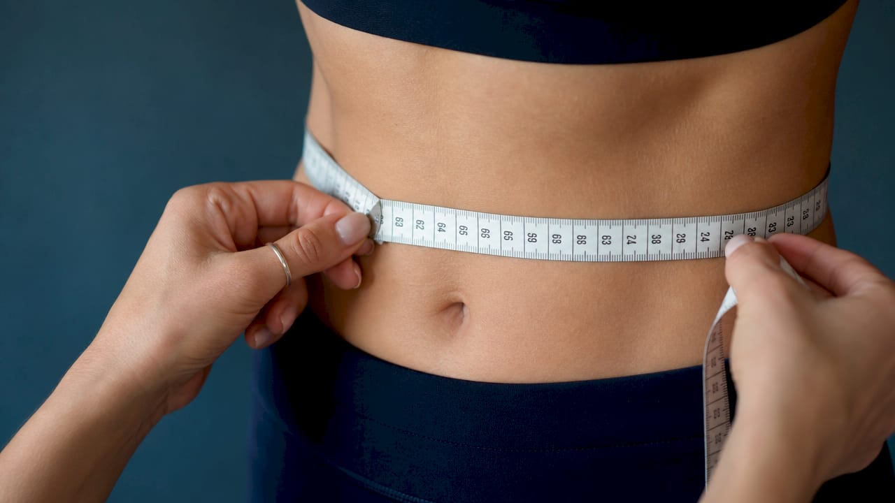 Measuring tape around natural waist close-up