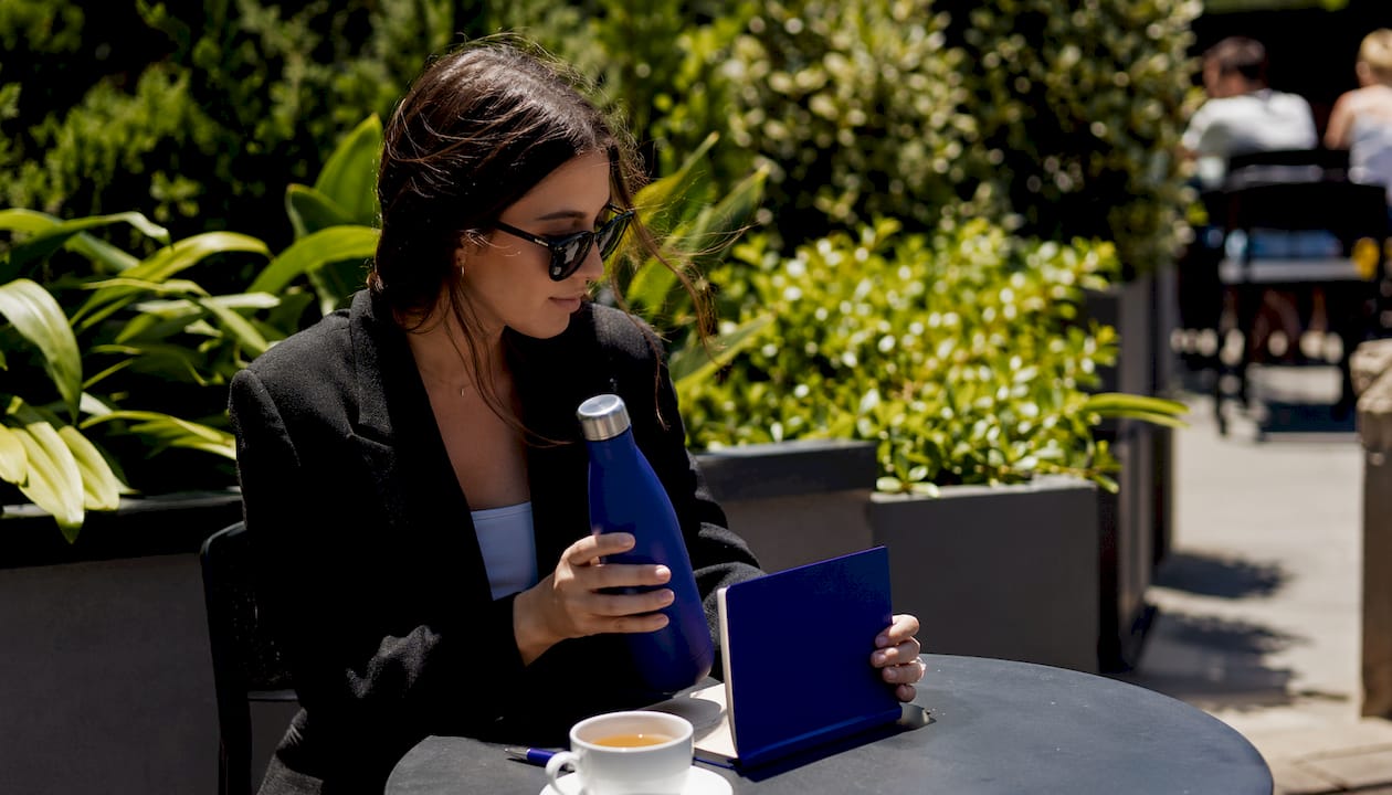 Hands inspecting useful branded swag items on table