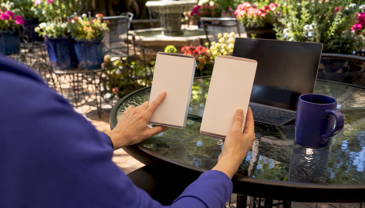 Hands comparing product package fonts over table