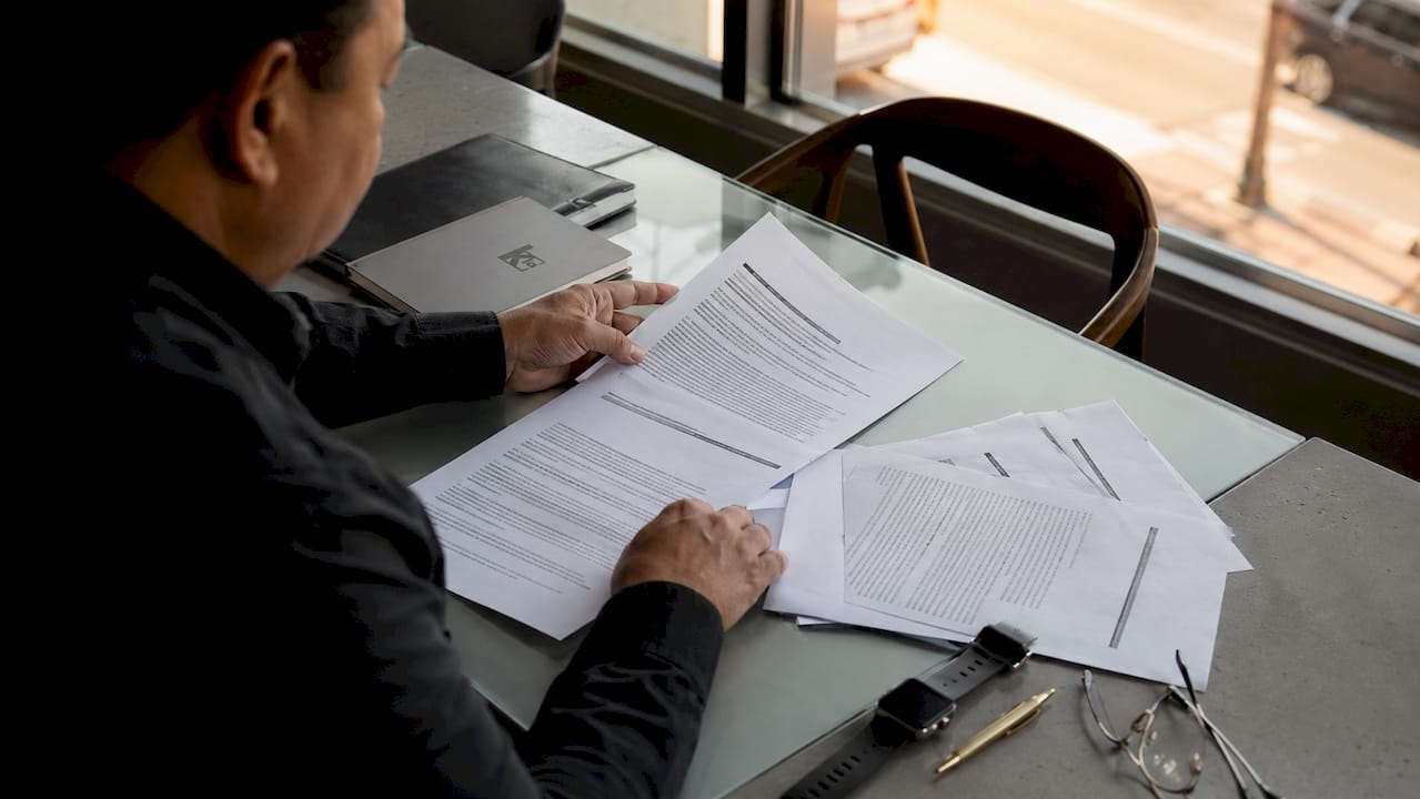 Hands sorting breach report documents