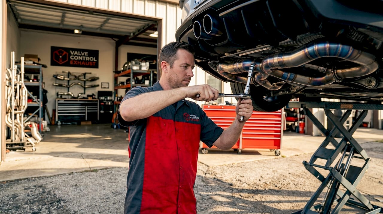 Technician installing titanium exhaust system