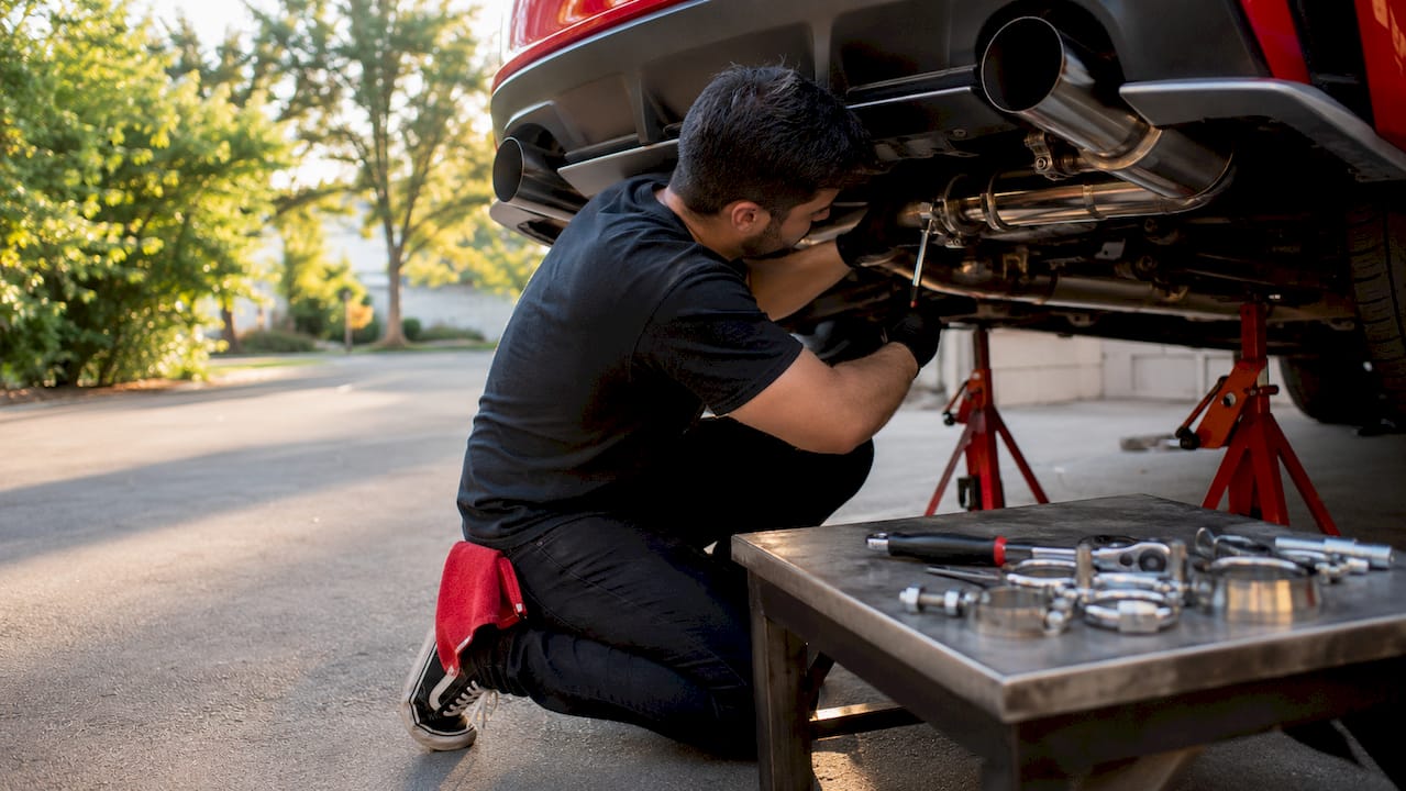 Hands installing cat-back exhaust pipe