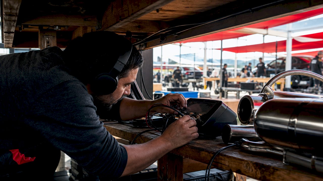 Engineer adjusting exhaust sound tuning equipment