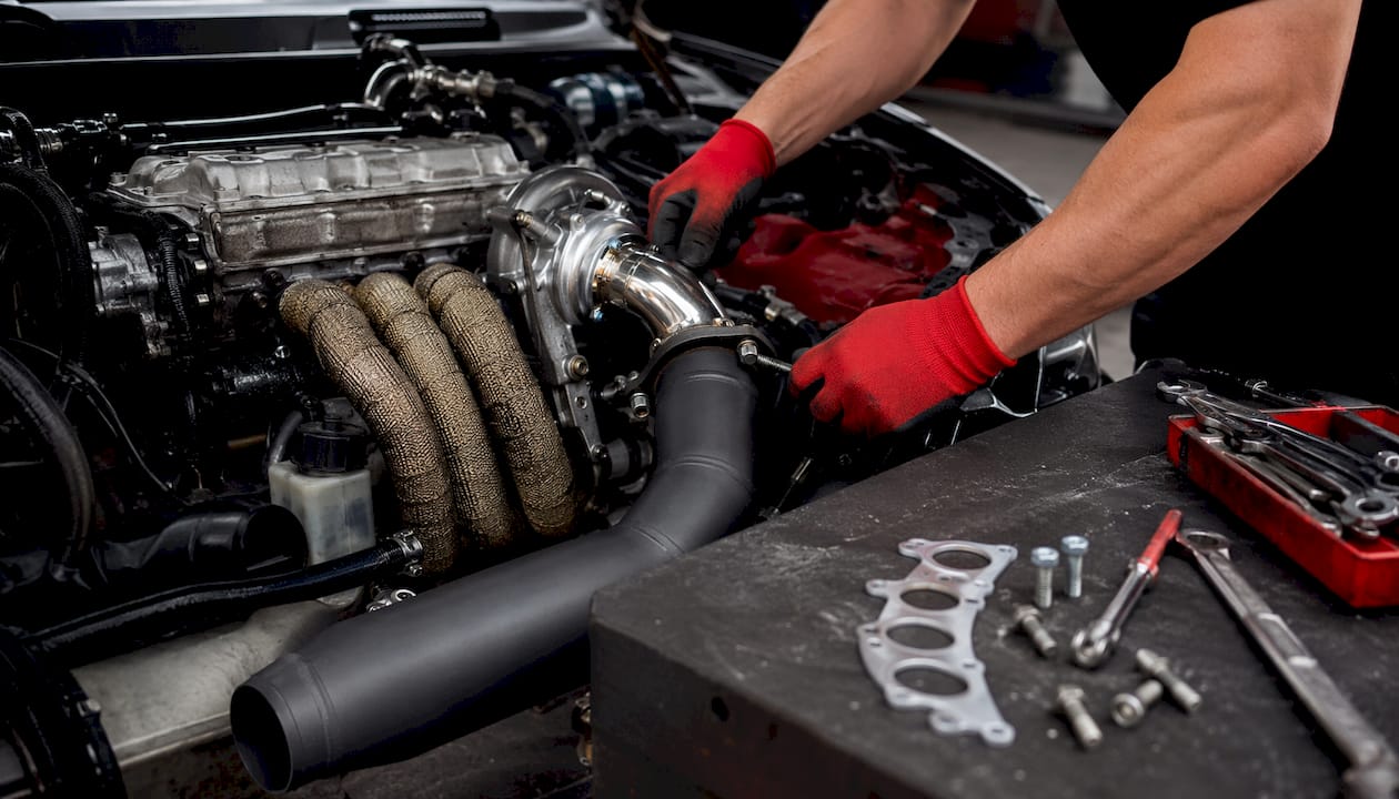 Close-up of mechanic installing aftermarket downpipe