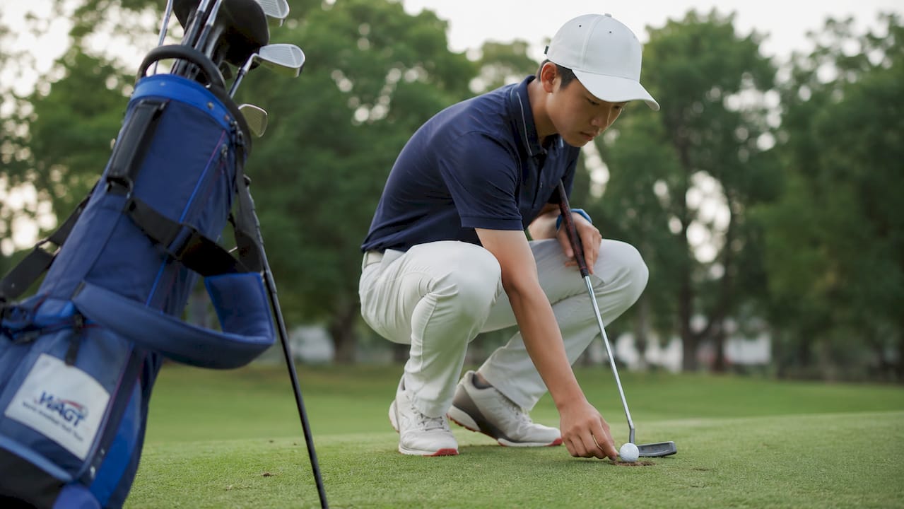Two juniors discussing golf scorecards at course