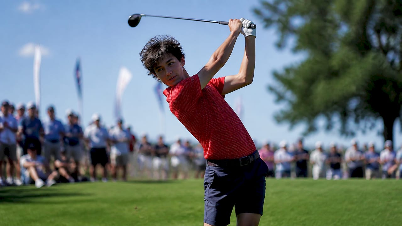Junior golfer swinging at high-level tournament
