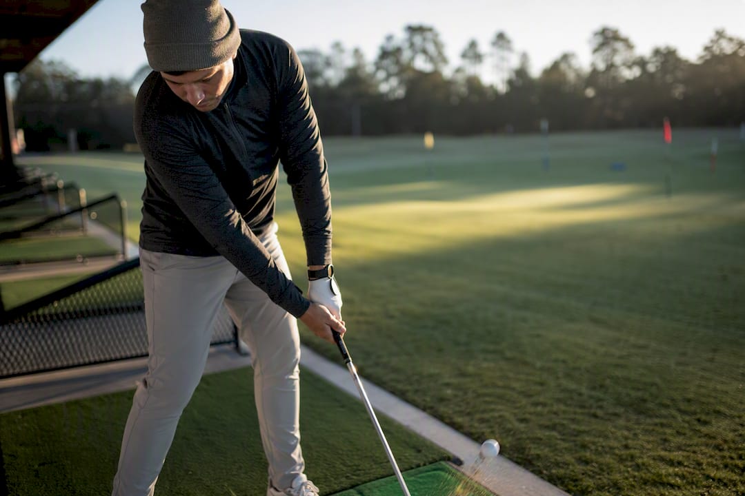 Golfer practicing knockdown shots at range