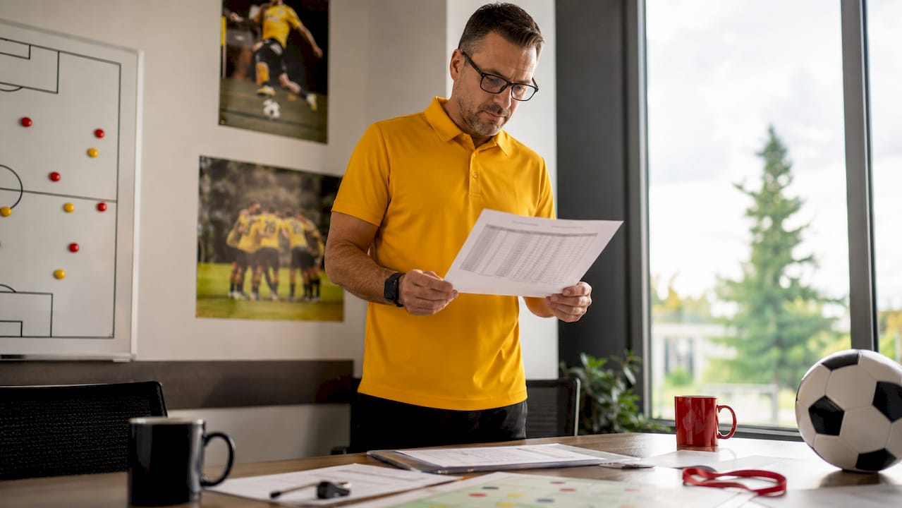 Coach reviewing soccer scholarship budget and roster