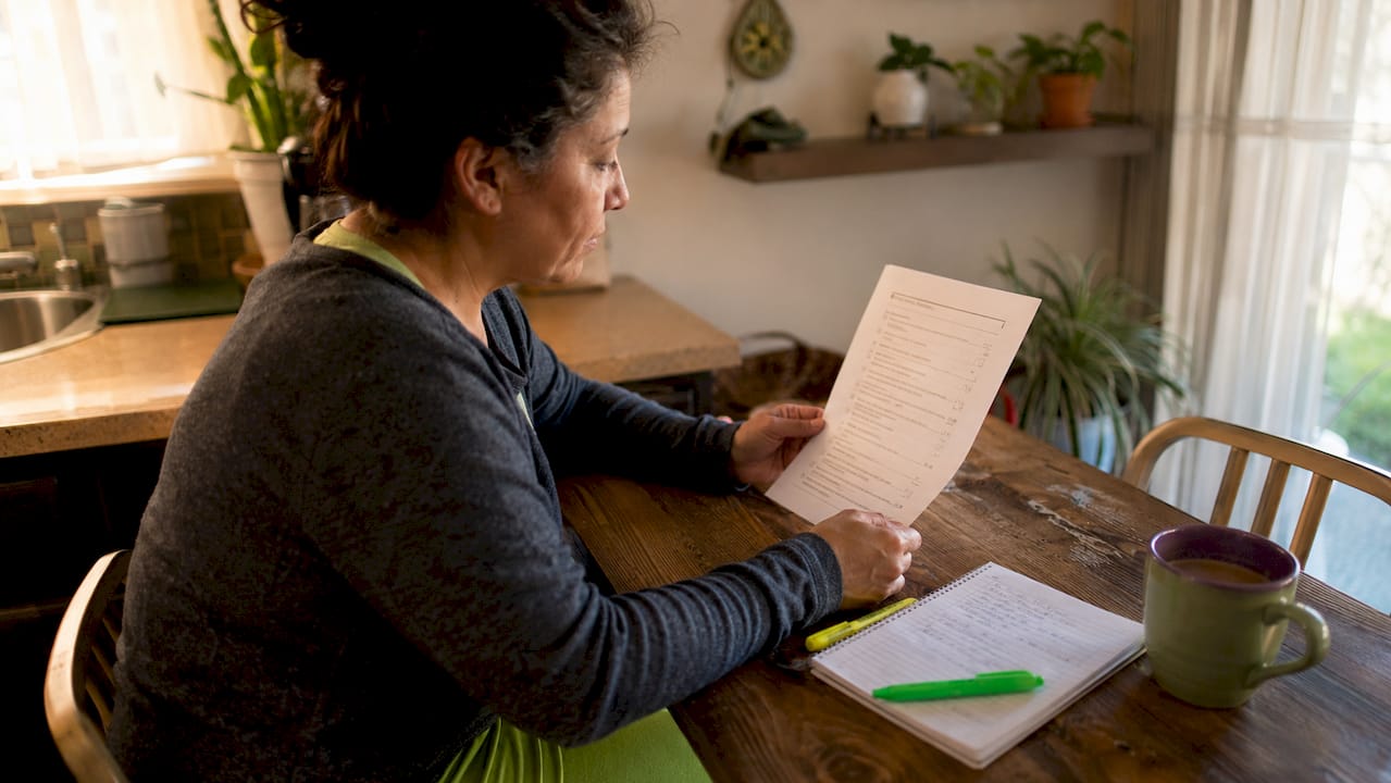 Homeowner reviewing roofing checklist at kitchen table