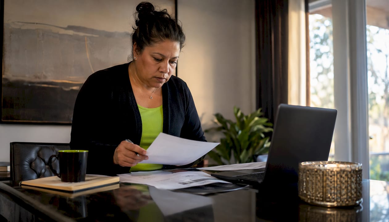 Homeowner reviewing roof financing papers at kitchen table