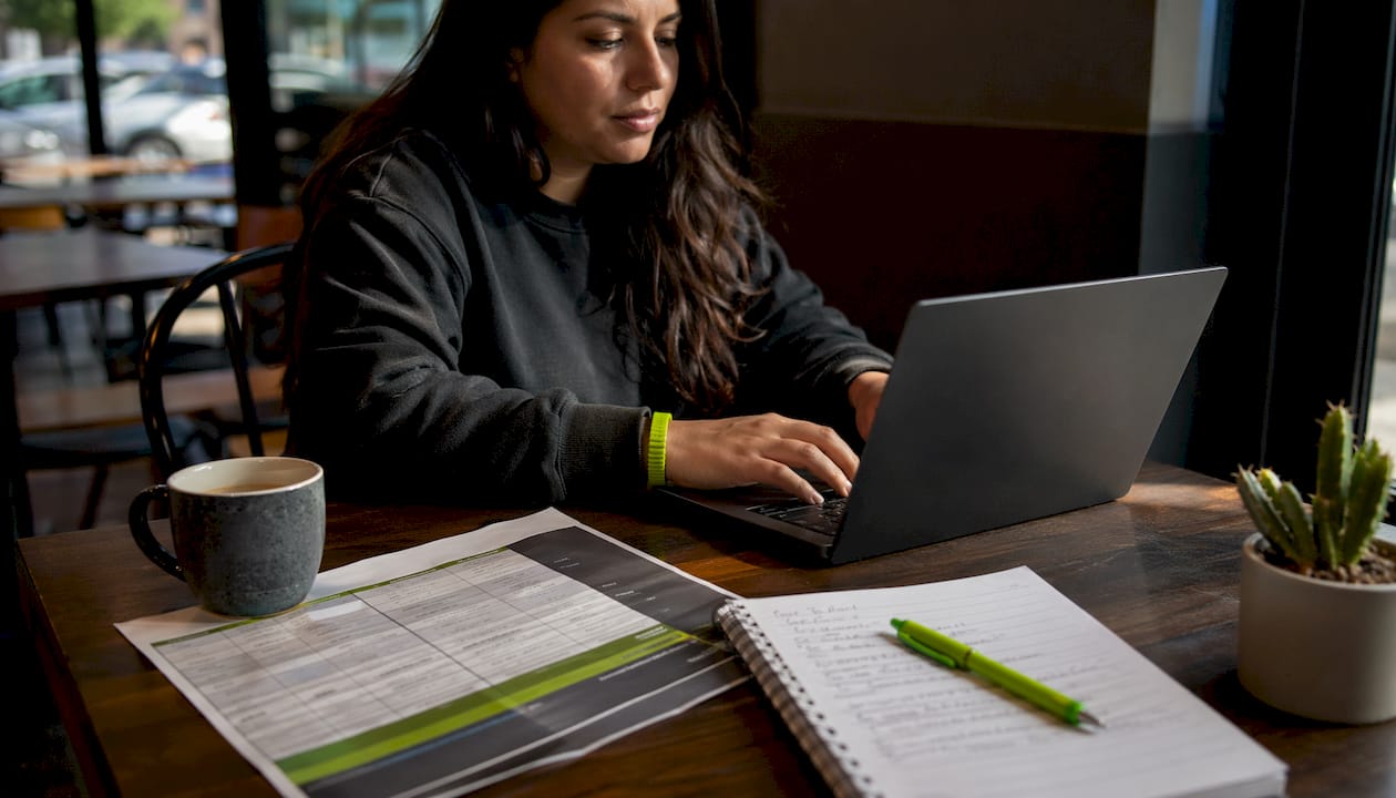 Hands typing with loan comparison chart nearby