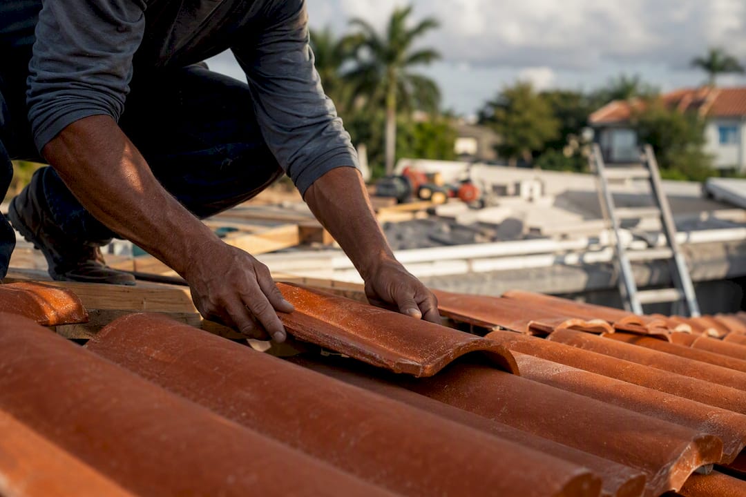 Hands installing terracotta tile roof