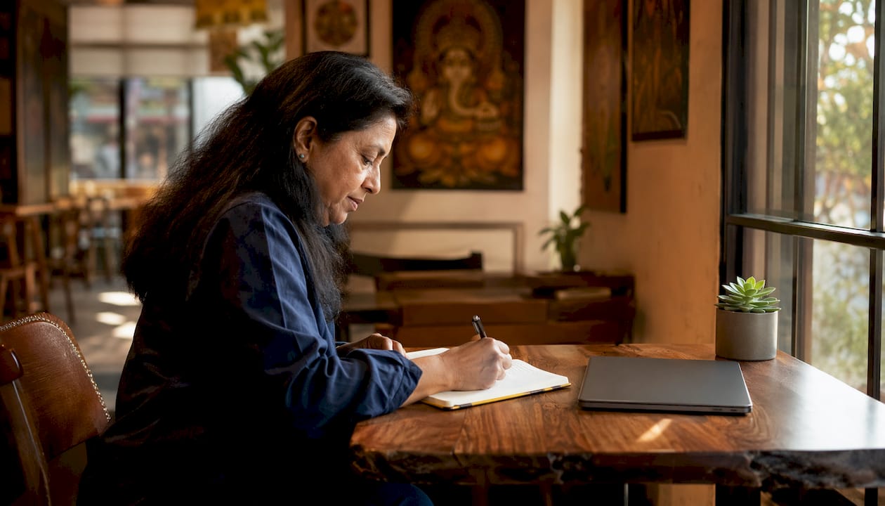 Author writing notes in home office