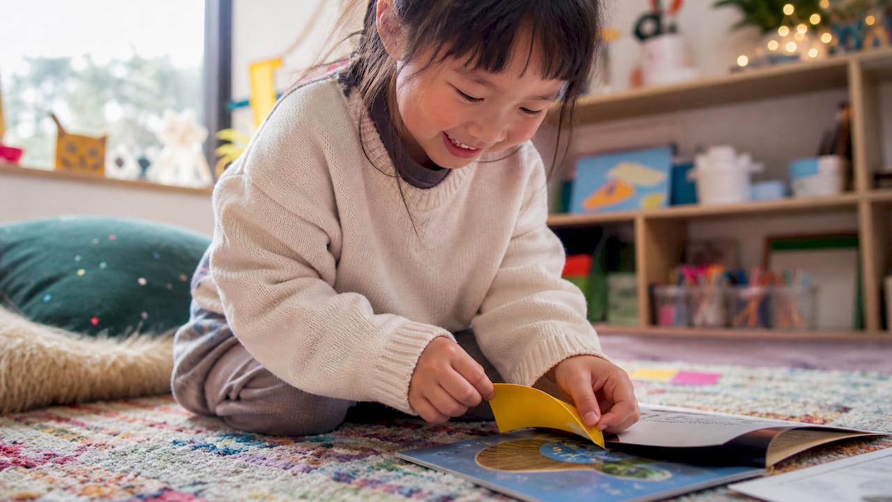 Child lifting sticky note off picture prompt