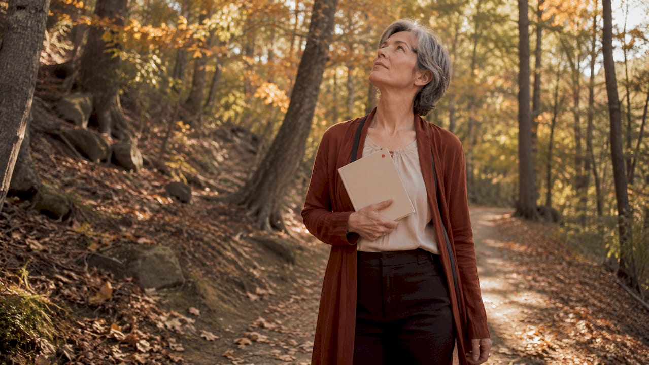 Woman walking reflectively in urban park