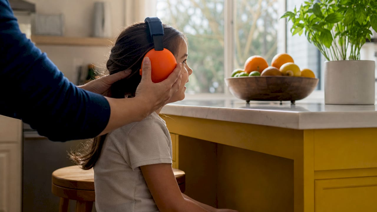 Close-up fitting earmuffs on child’s head