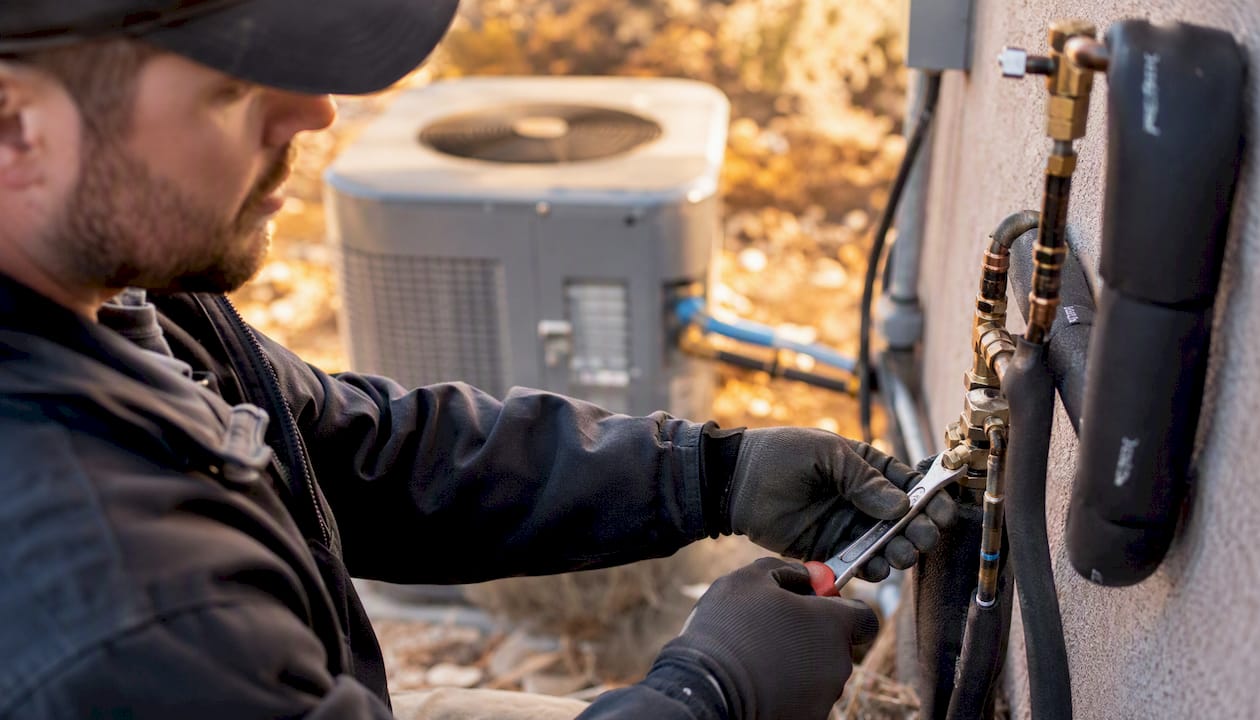 Technician installing heat pump outdoors