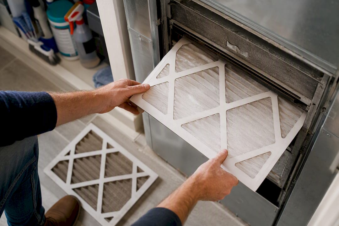 Hands installing HVAC air filter