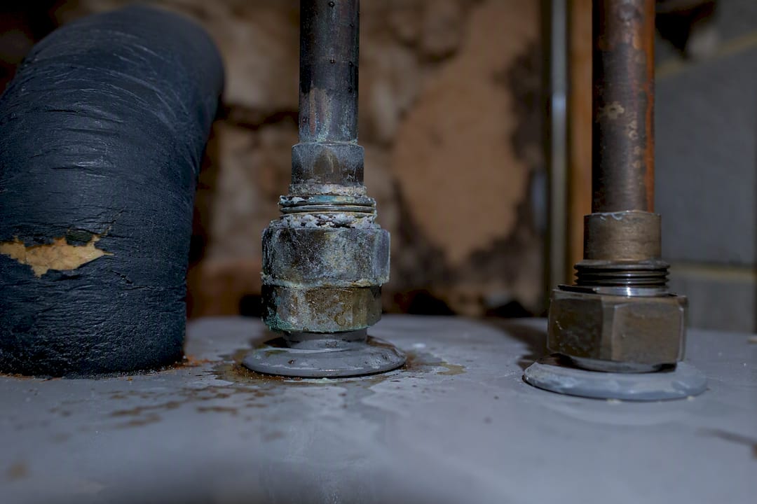Corroded dielectric union and loose pipe fittings on water heater