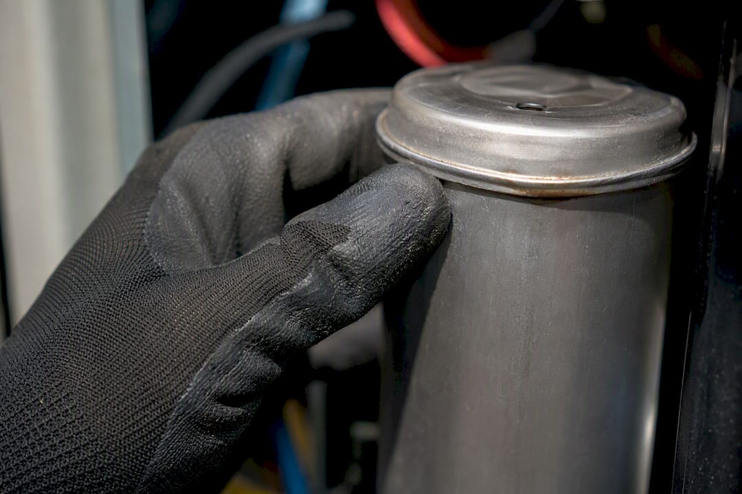Technician inspecting swollen blower capacitor