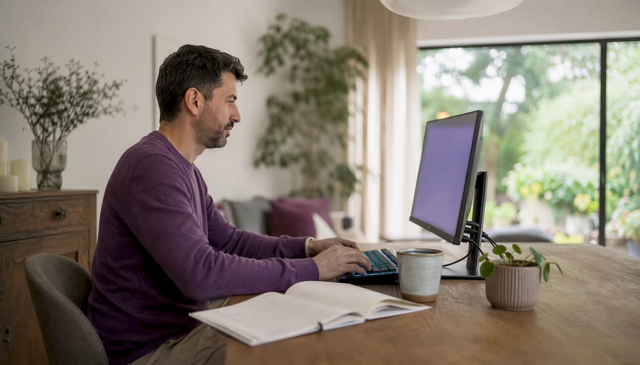 Dedos escribiendo rápidamente sobre el teclado, realizando pequeñas tareas en el escritorio
