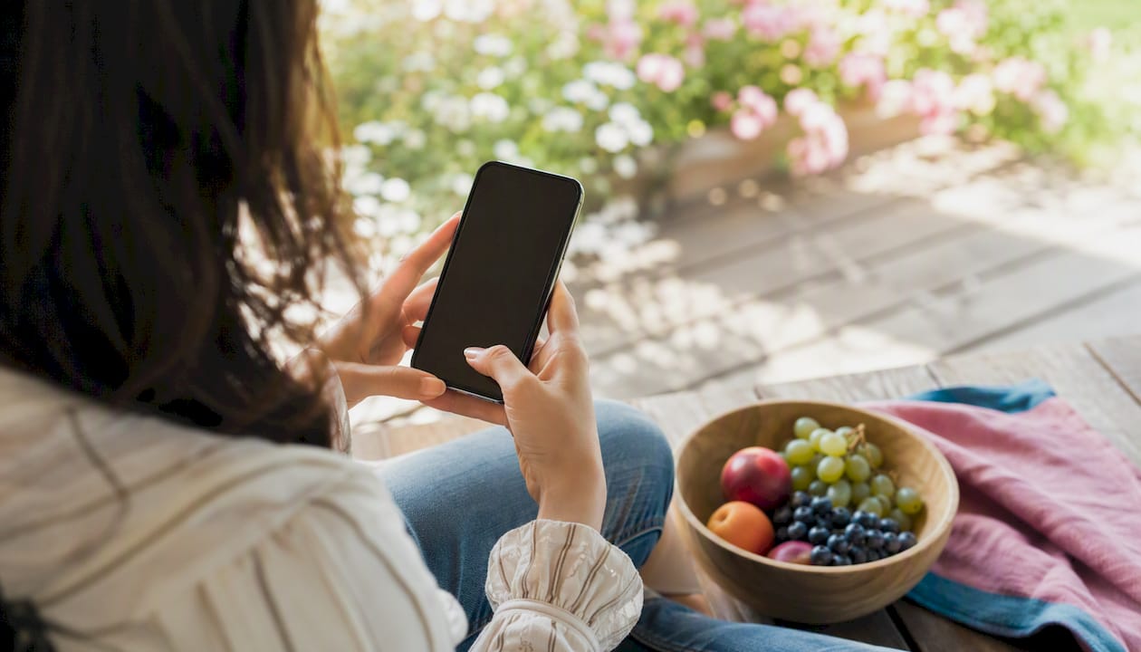 Woman transferring money on smartphone outdoors