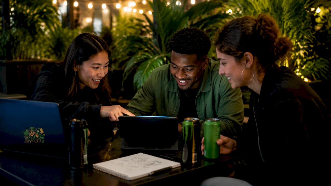 Group discussing trending games on laptop in café