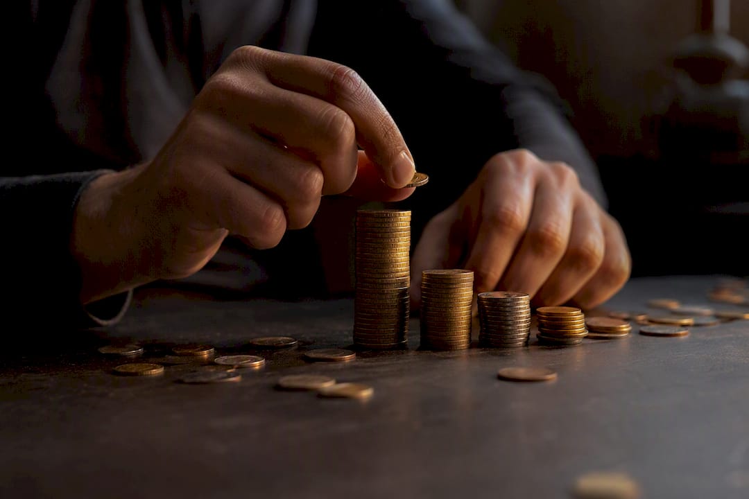 Hands stacking coins strategically