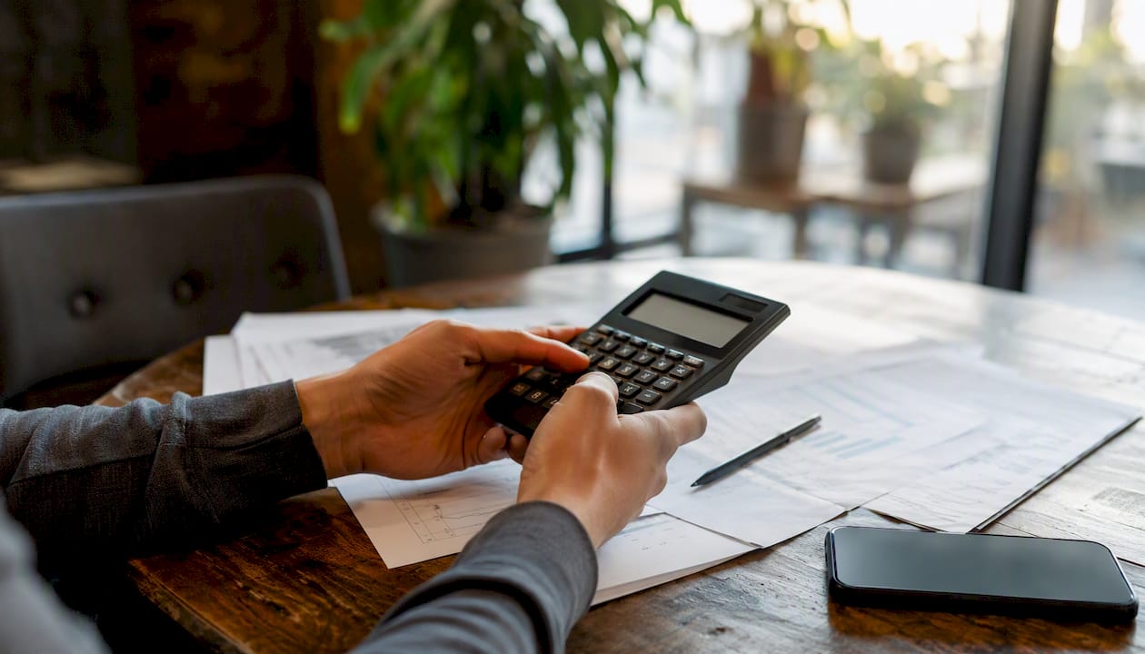 Hands calculating real estate financials on desk