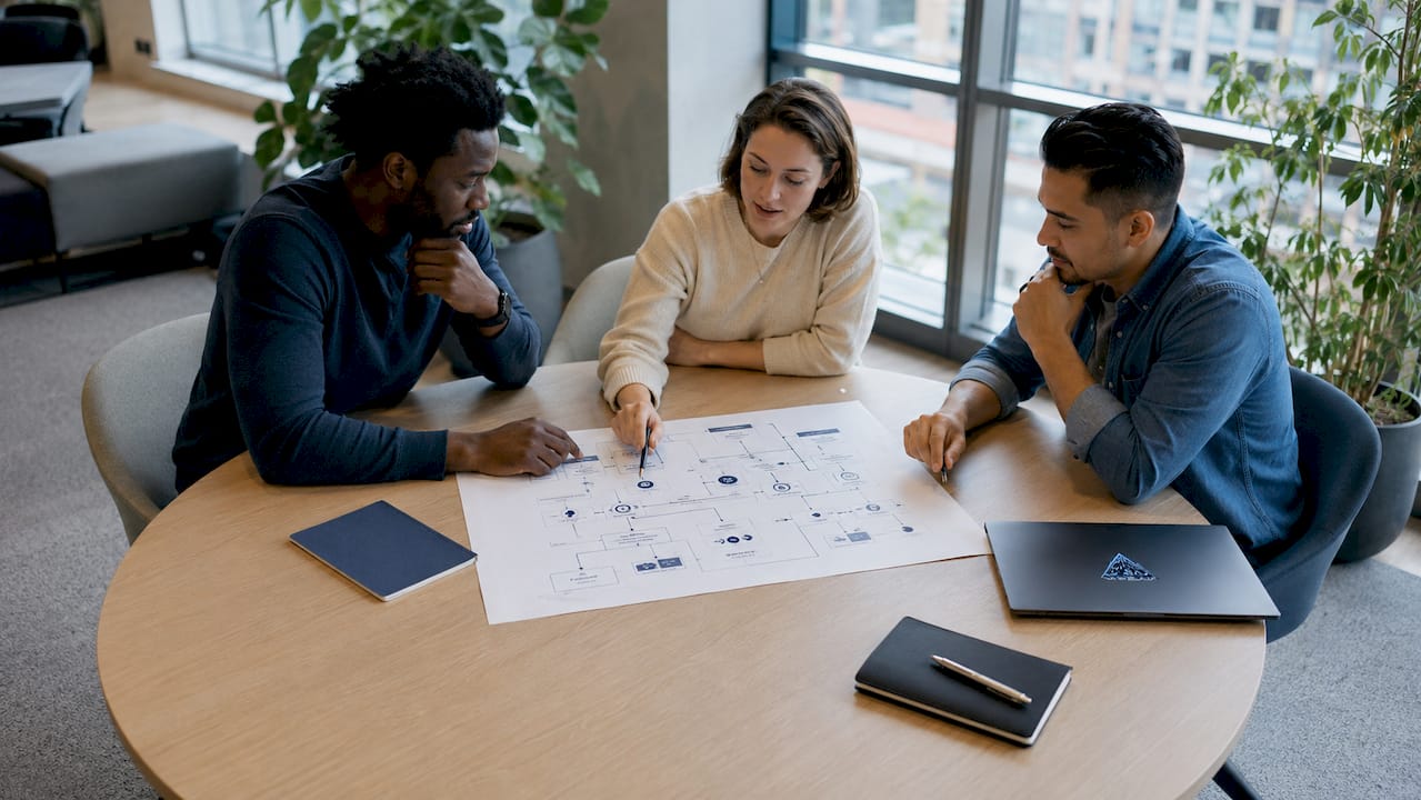 Hands collaborating on encryption schematic at desk