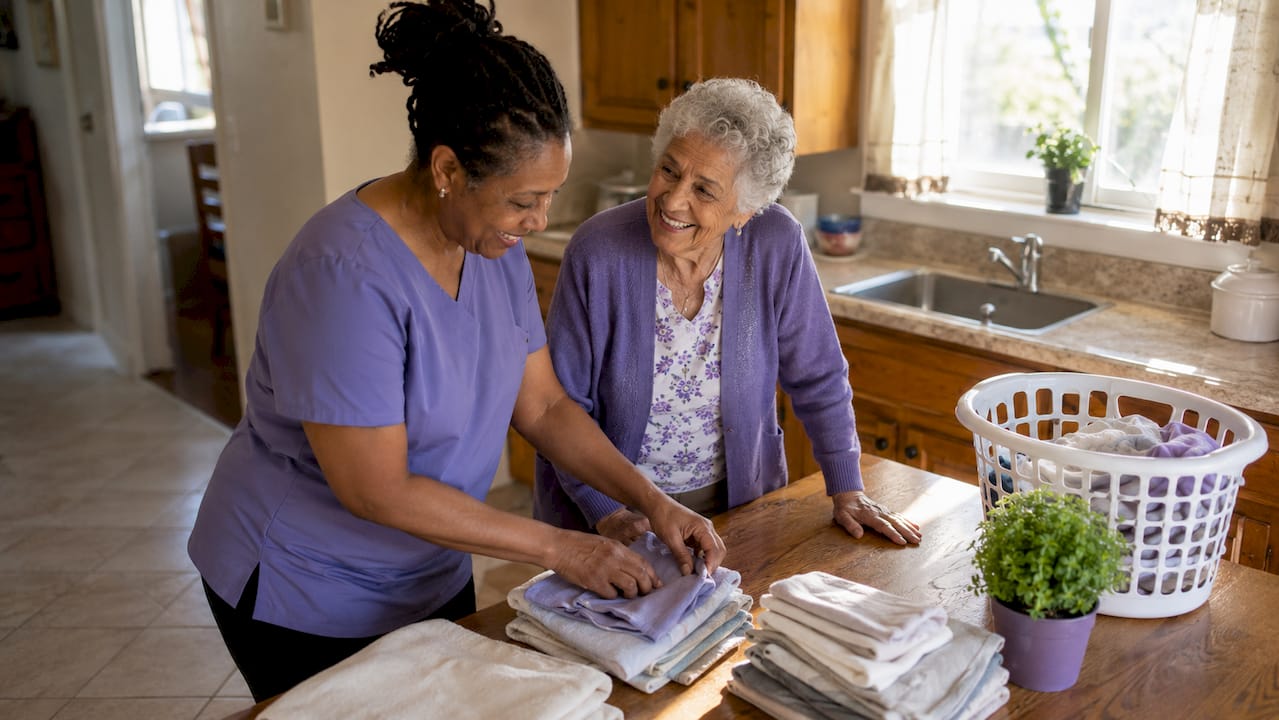 Care aide helping elderly woman with chores