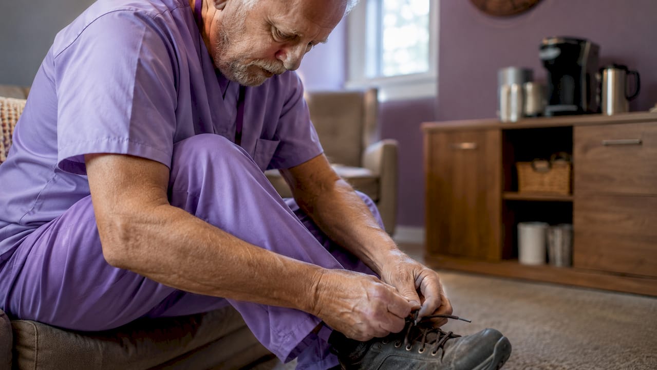 Home care worker tying shoes in break room