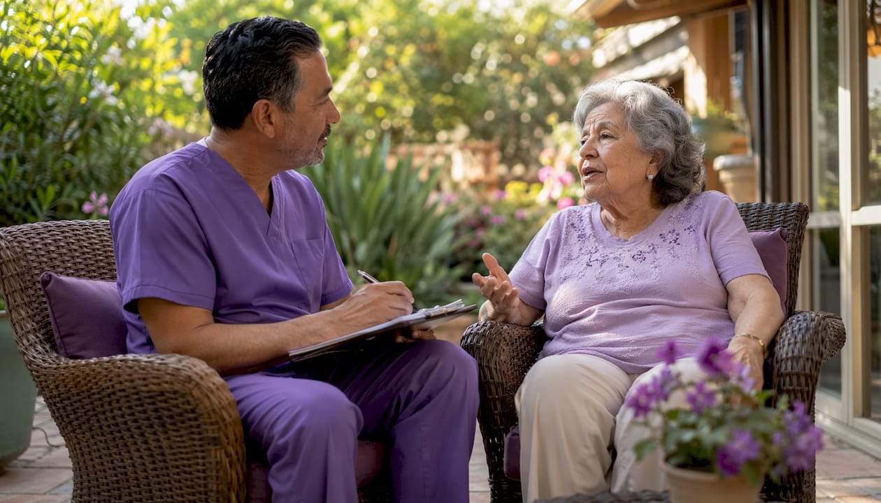 Caregiver attentively listening to elderly patient at home