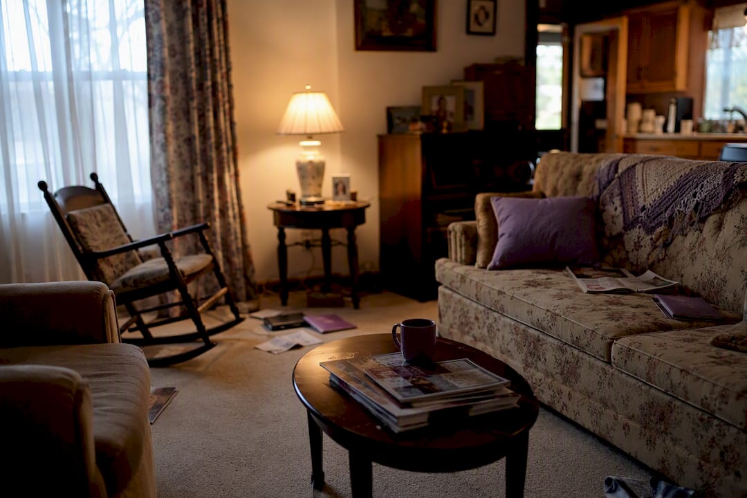Cluttered dimly lit senior living room corner
