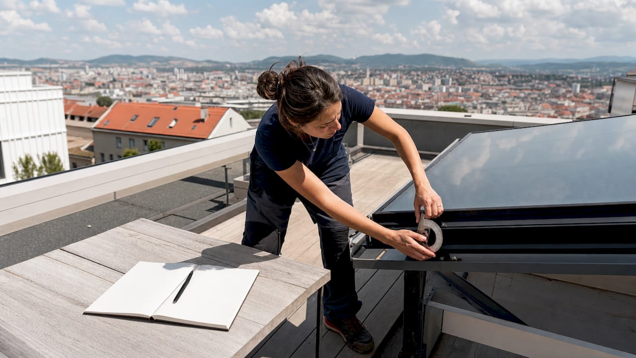 Une femme en train de vérifier l’orientation d’un panneau solaire à l’aide d’un instrument de mesure.