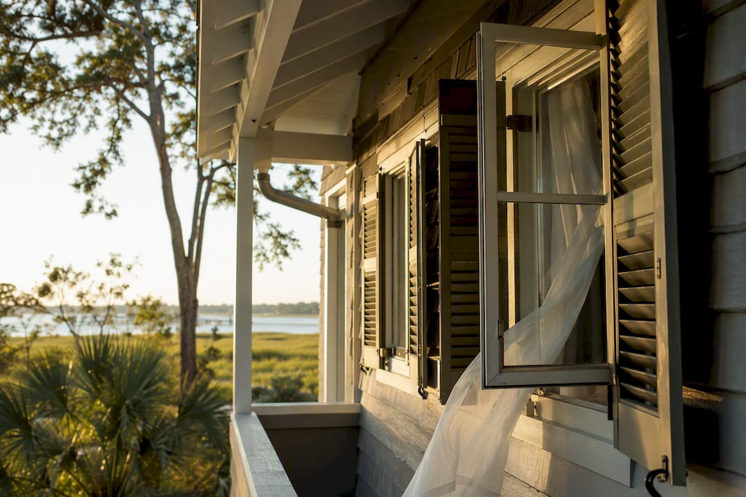 Coastal home exterior showing open windows for ventilation