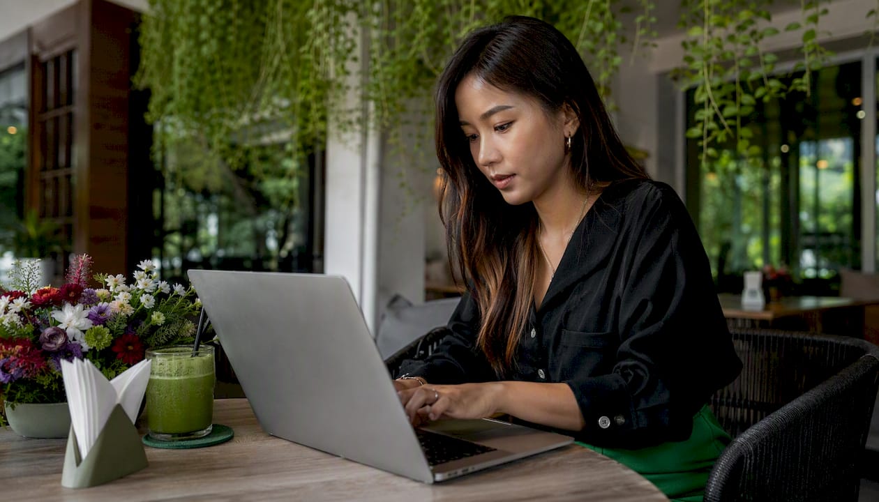 Hands typing solo ad email copy in café